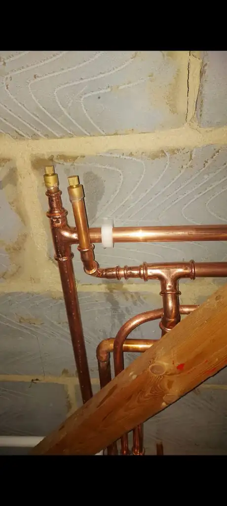 Copper pipework run and clipped between floor joists