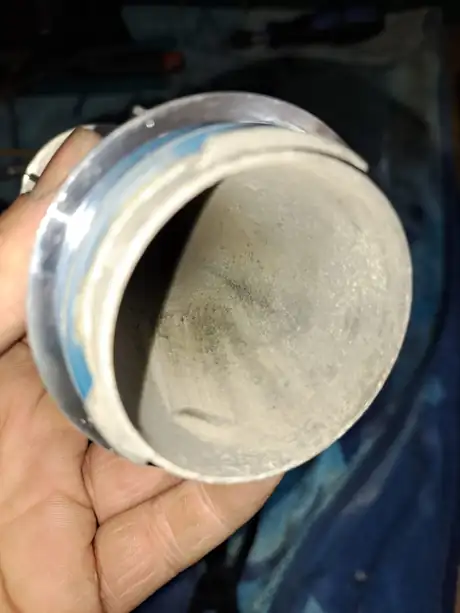 A sooted flue section held in the hand