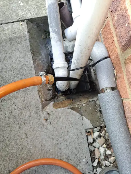 A gas supply pipe entering the house below the wall