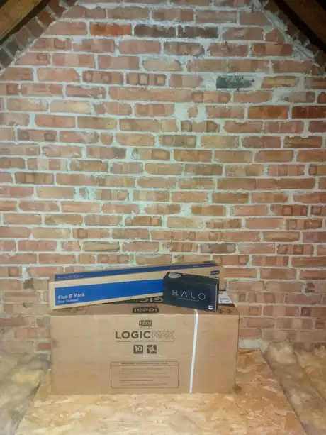 A new boiler and flue kit boxed up in a loft ready to fit