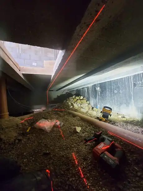 Pipework run through a crawl space, set out with a laser level