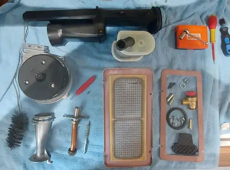 The full service kit laid out on a mat: burner, gaskets, brush and electrodes