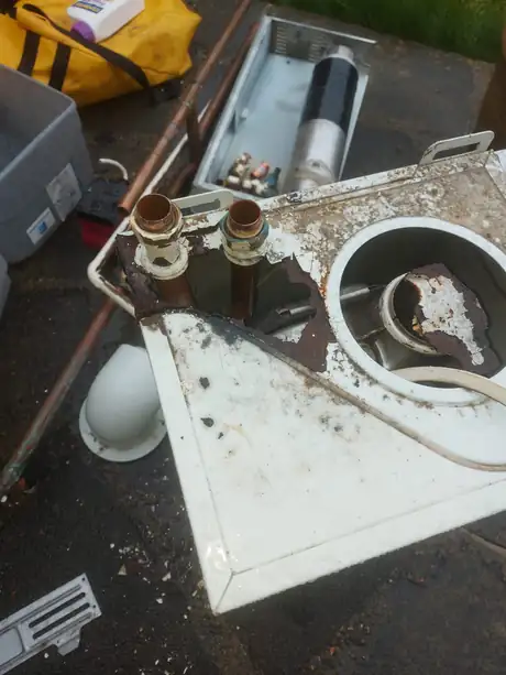 An old boiler taken off the wall and dismantled outside