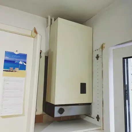 An old boiler in a cupboard before replacement