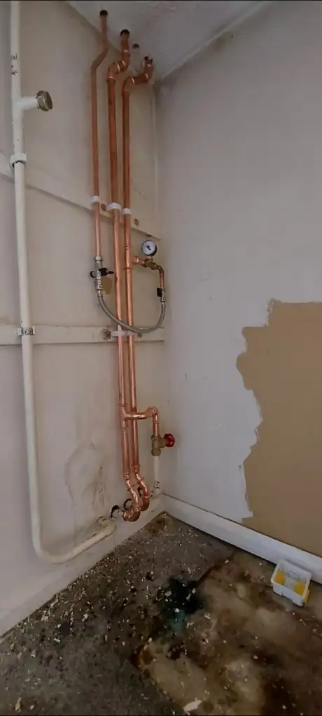 New copper pipework on the wall with the floor stripped back