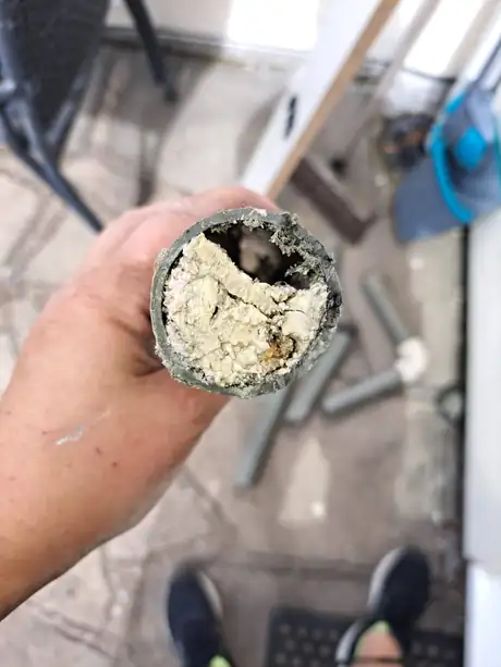 A section of pipe held up, blocked solid with debris