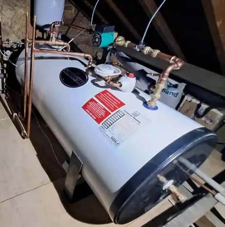 A new hot water cylinder fitted in a loft