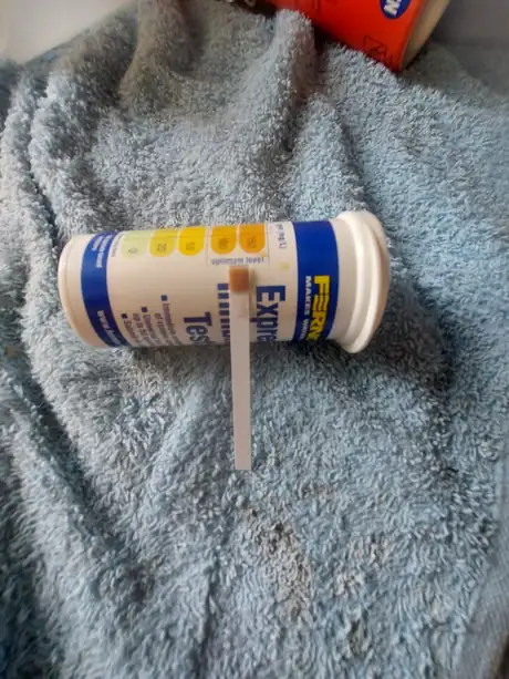 A Fernox water test strip laid out after sampling the system