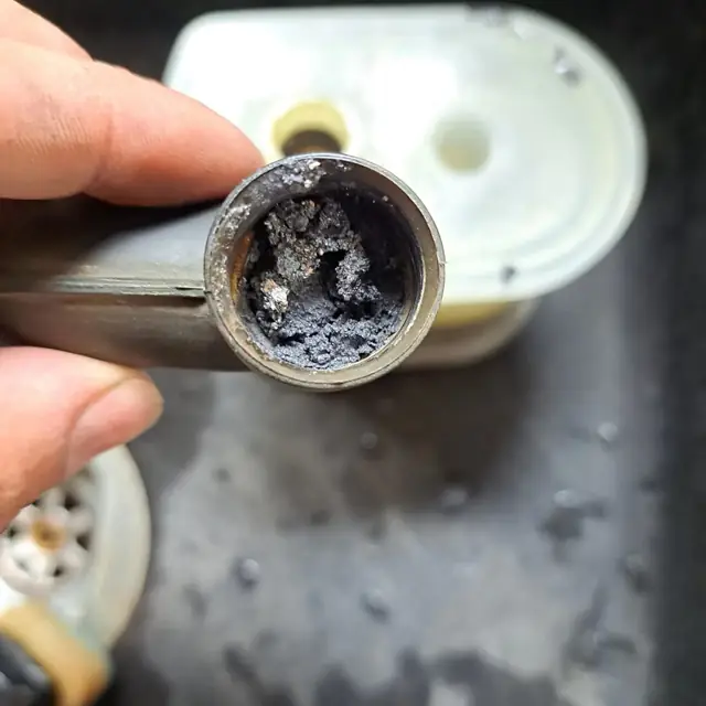 The open end of a condense pipe from an Ideal Logic boiler, blocked solid with dark debris
