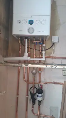 A boiler installed with the pipework run cleanly beneath it