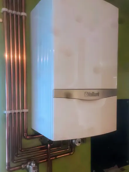 A Vaillant boiler on the wall with the copper pipework run in straight, even lines beneath it